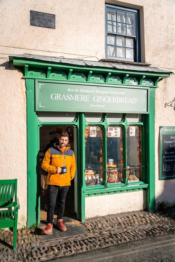 man having coffee outside grasmere gingerbread shop in hawkshead
